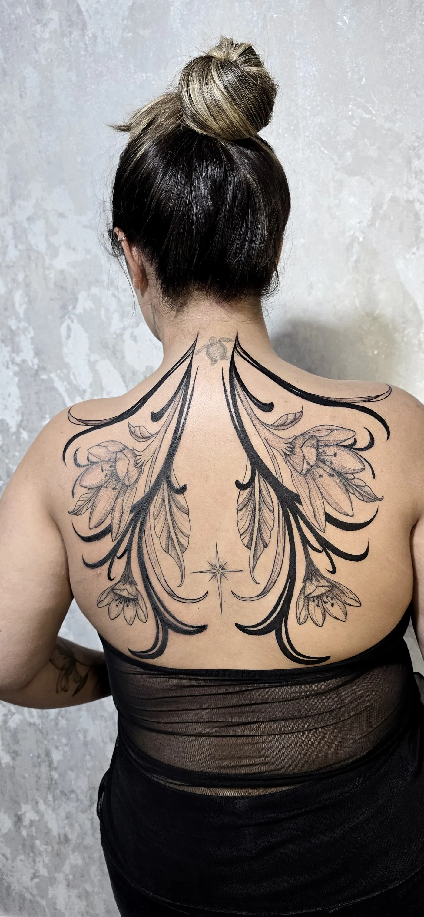 Asas ornamentais com folhagem cobrindo as costas