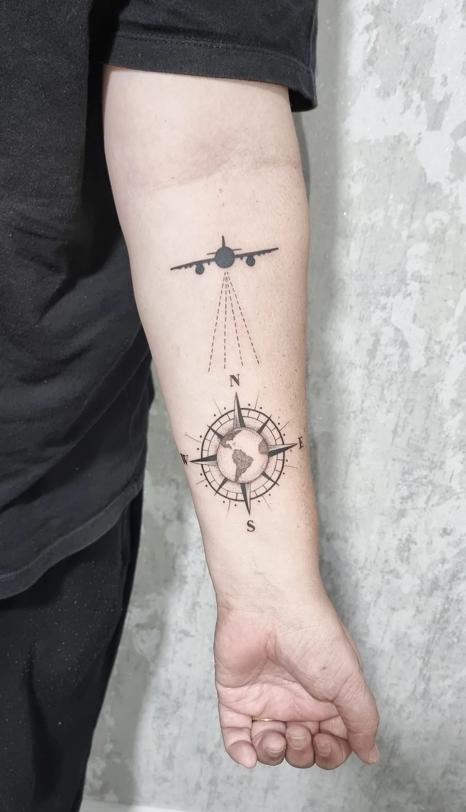 Avião e rosa dos ventos em traço fino no antebraço
