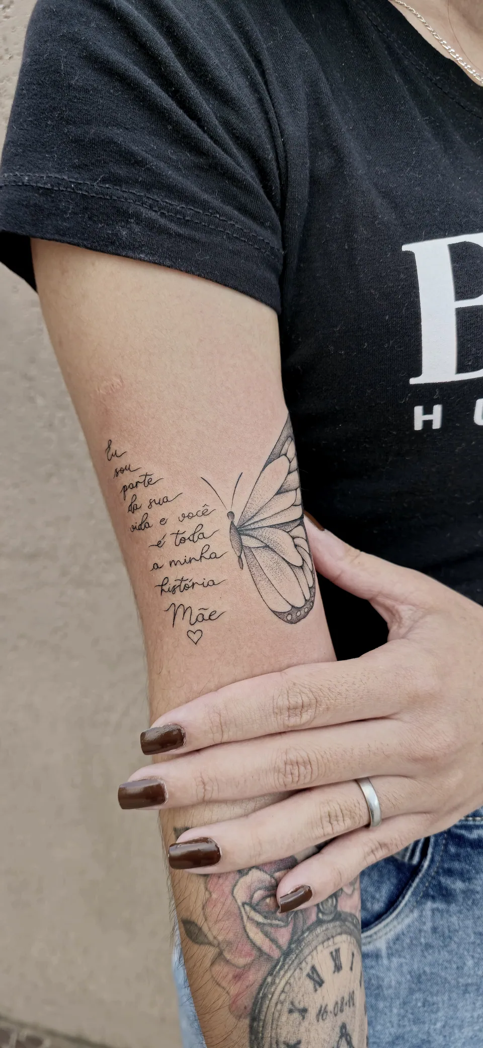 Borboleta com frase de homenagem à mãe no braço