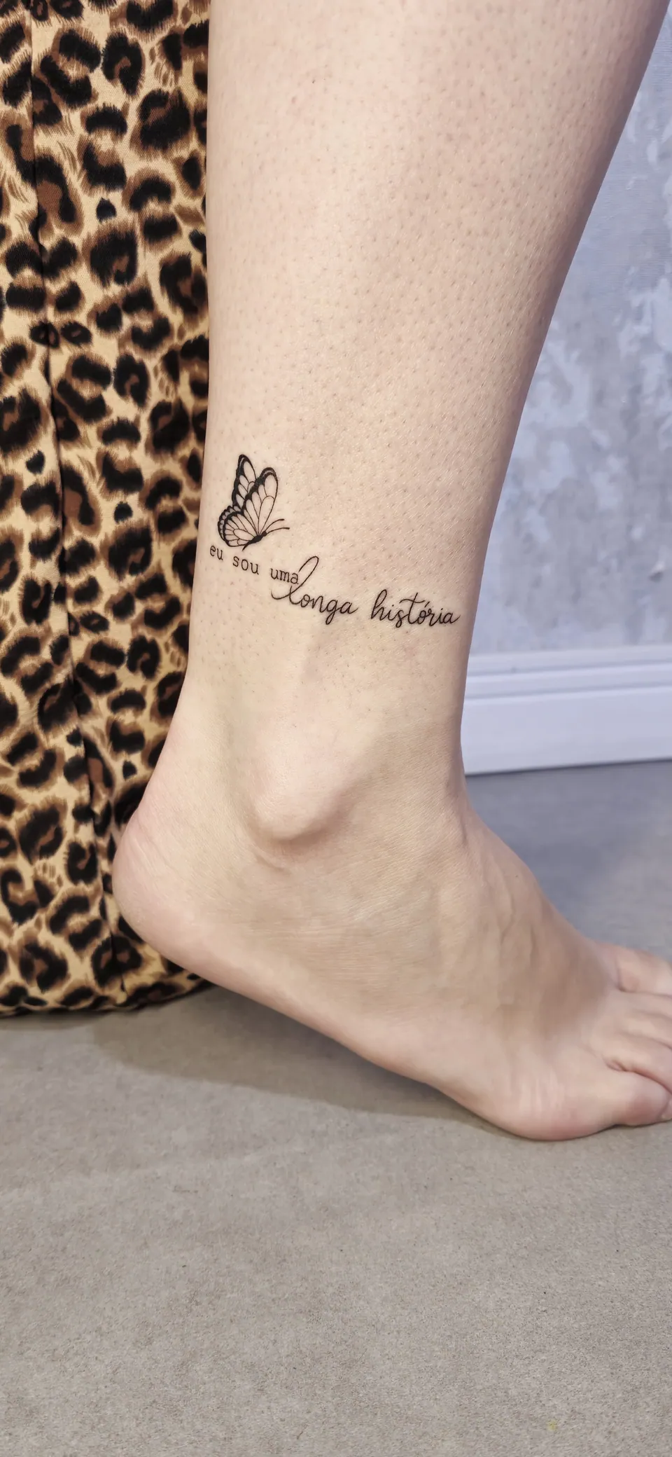 Borboleta com frase em lettering no tornozelo