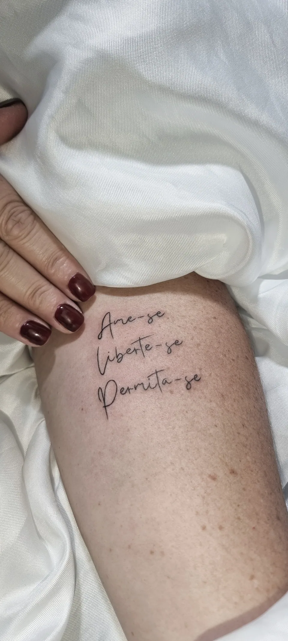 Lettering em três linhas na lateral da coxa