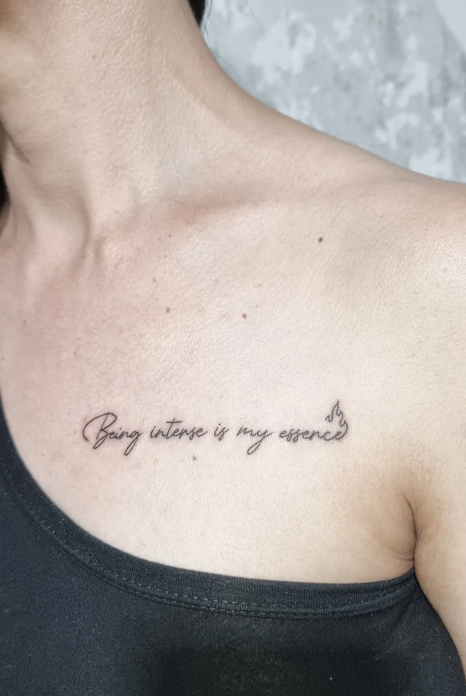 Frase em lettering delicado na clavícula