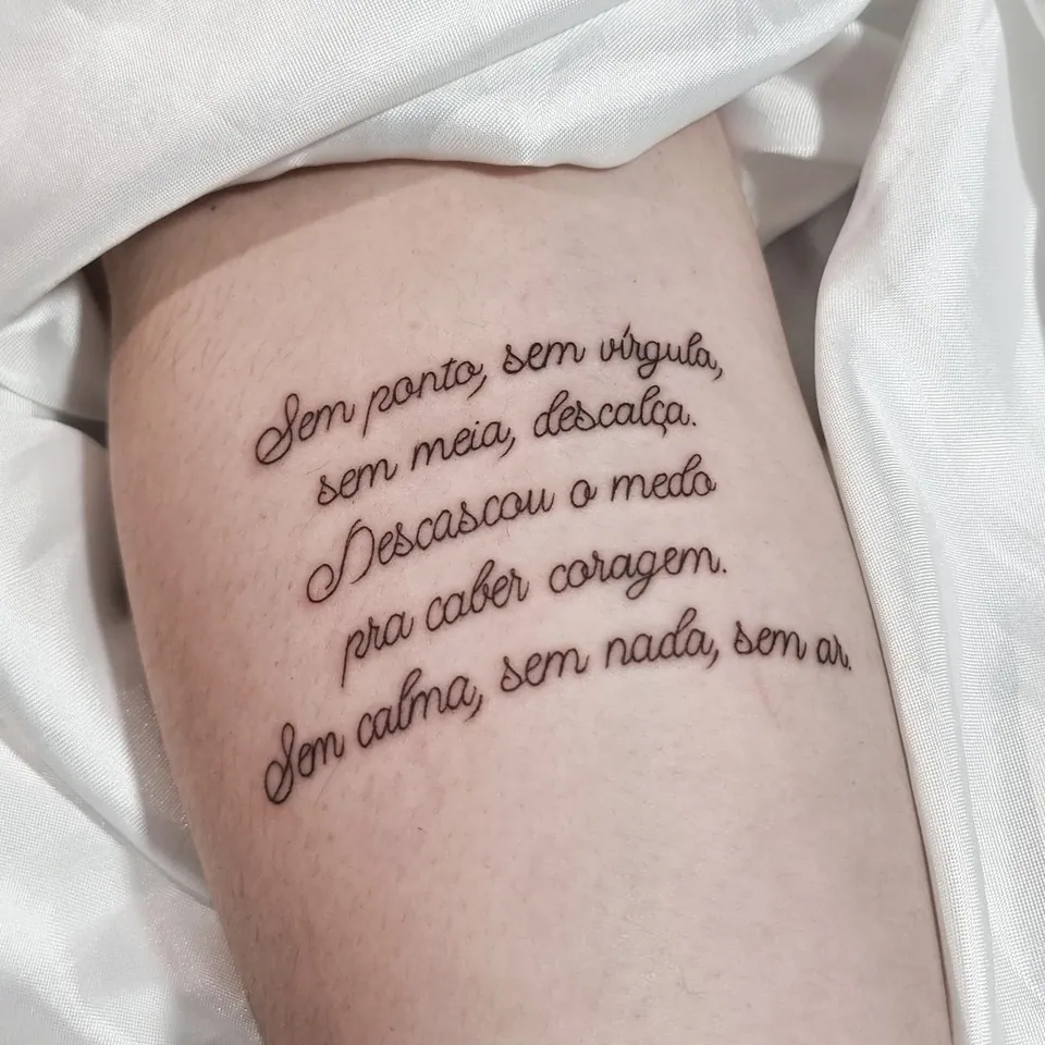 Poema em lettering cursivo na coxa