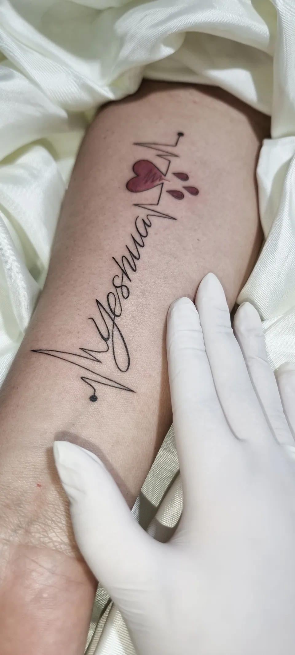 Lettering cursivo com traço musical no antebraço