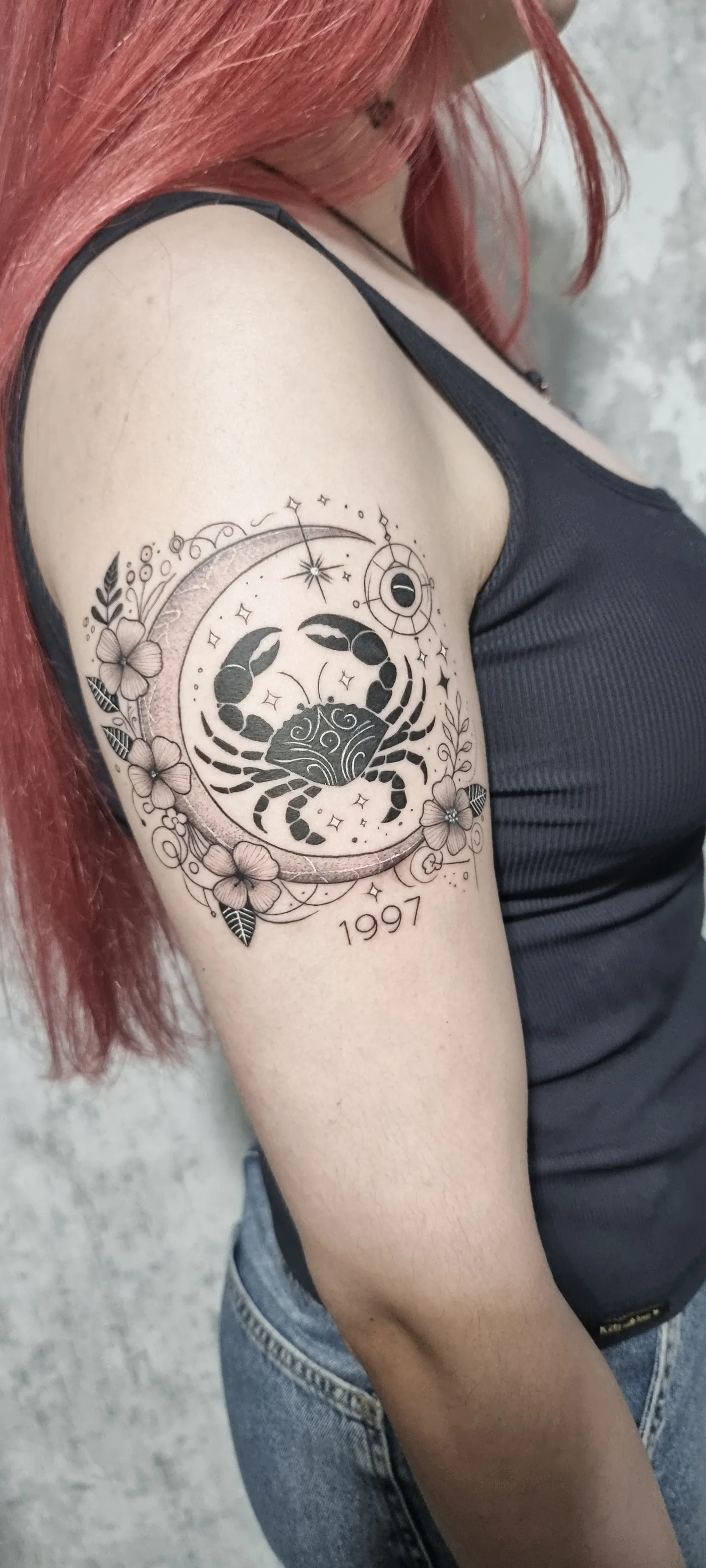 Lua com signo e elementos florais no braço