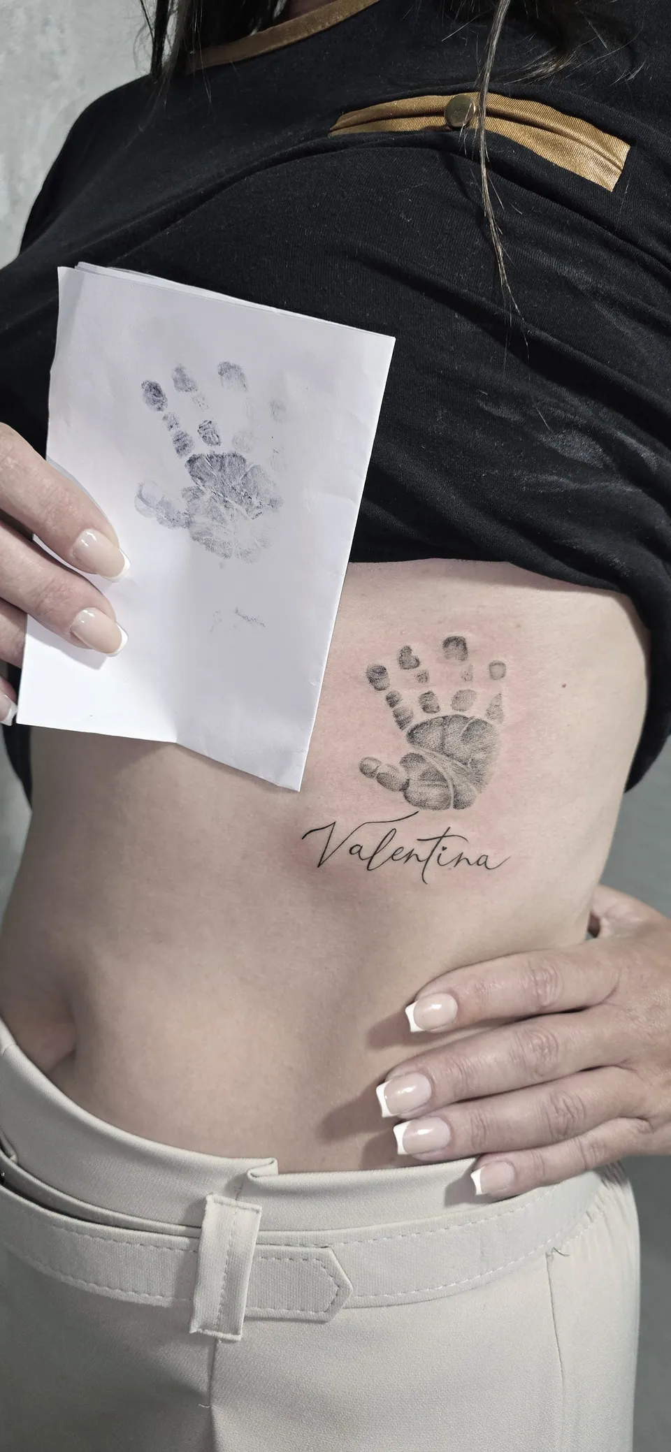 Mãozinha de bebê com nome em lettering na costela